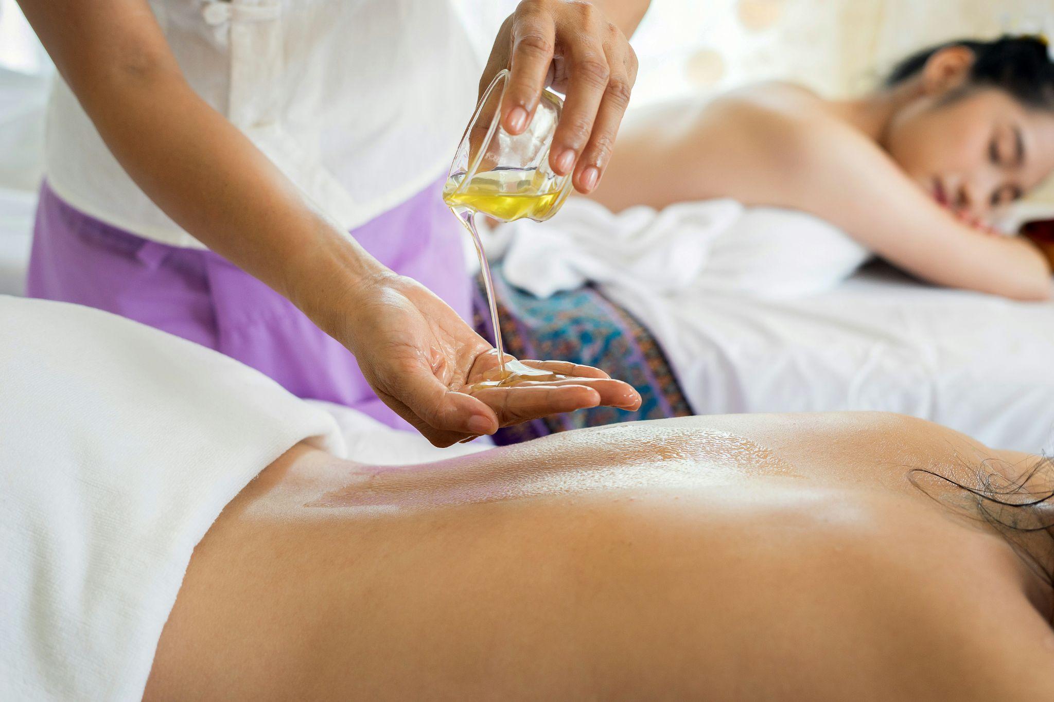 A therapist pours massage oil before providing a relaxing at-home massage in Clovis.