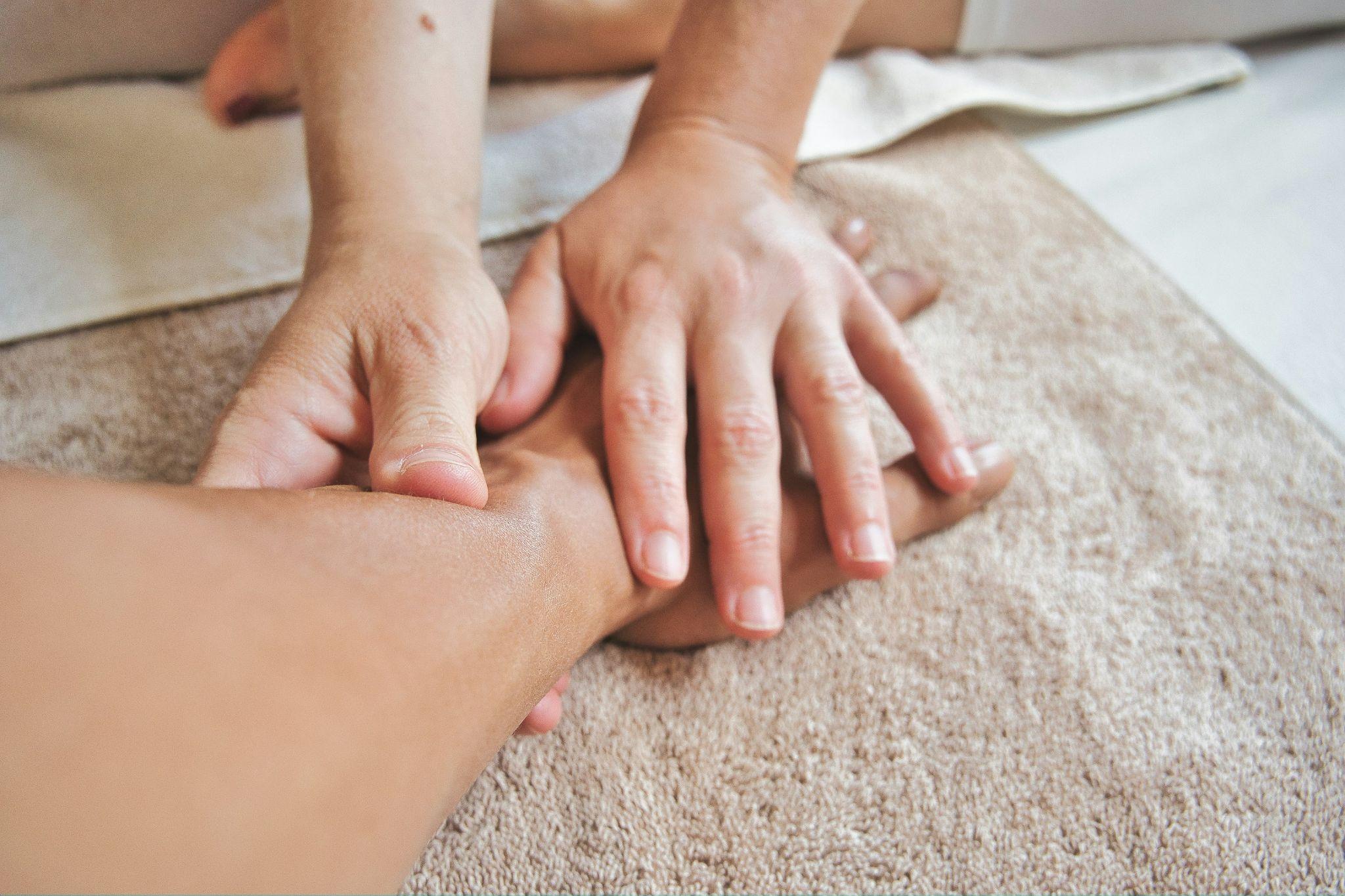 A massage professional works on a client’s leg as part of mobile massage therapy in Clovis.