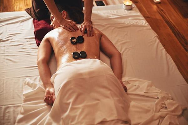 Heated basalt stones being used during hot stone massage therapy in Central Valley.